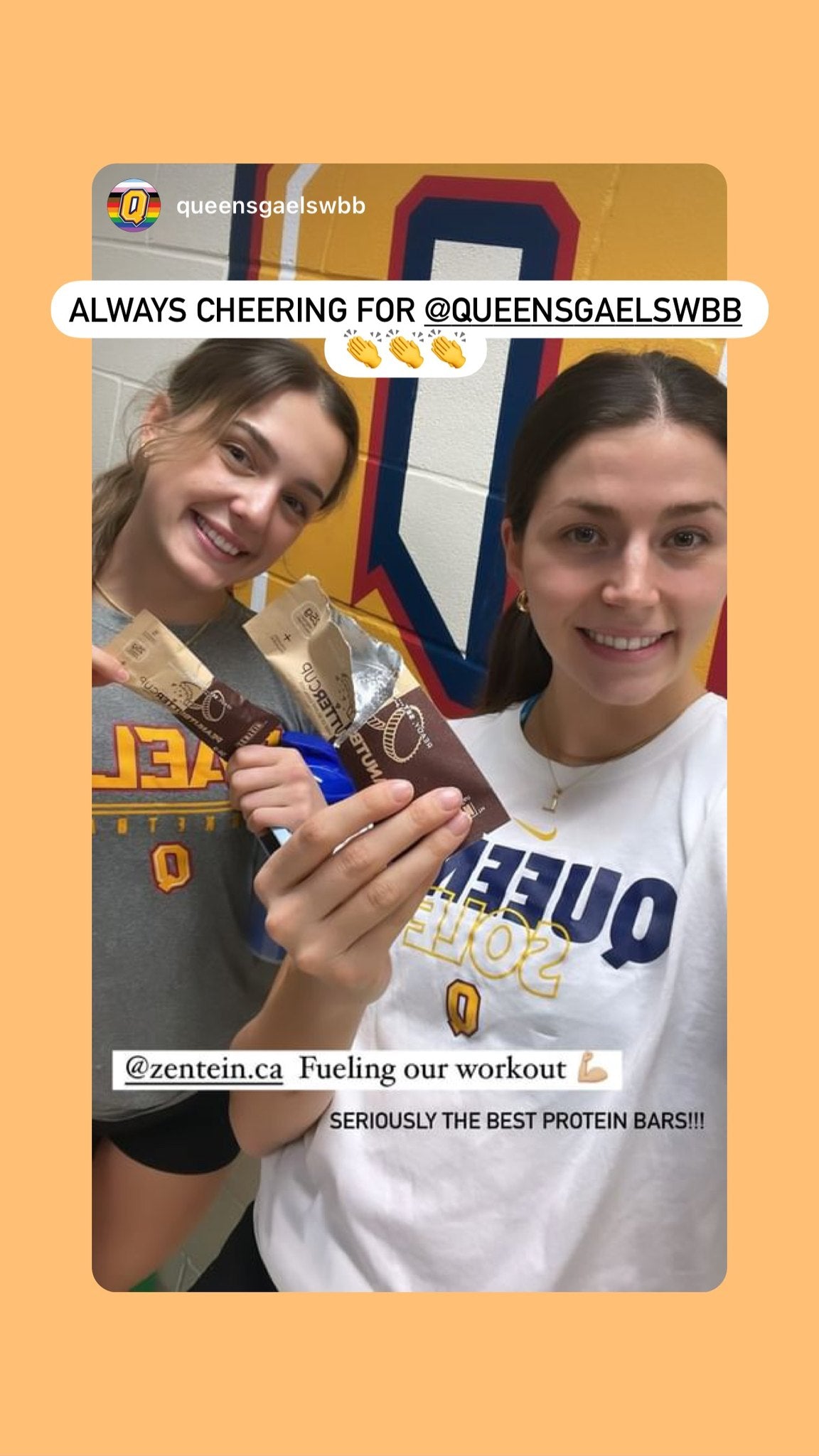 Two Queen's basketball teammates smile while holding Peanut Butter Cup wrappers.