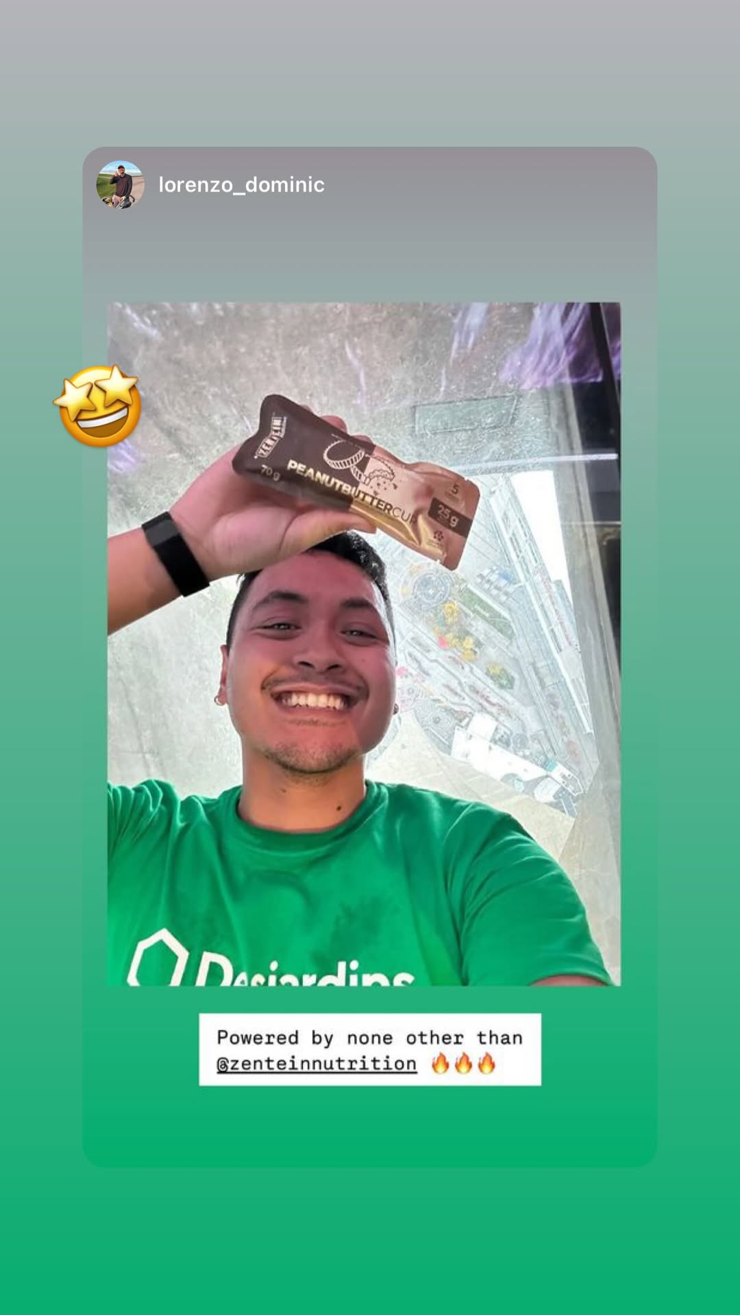 Lorenzo smiles while holding a wrapped Peanut Butter Cup above his head.