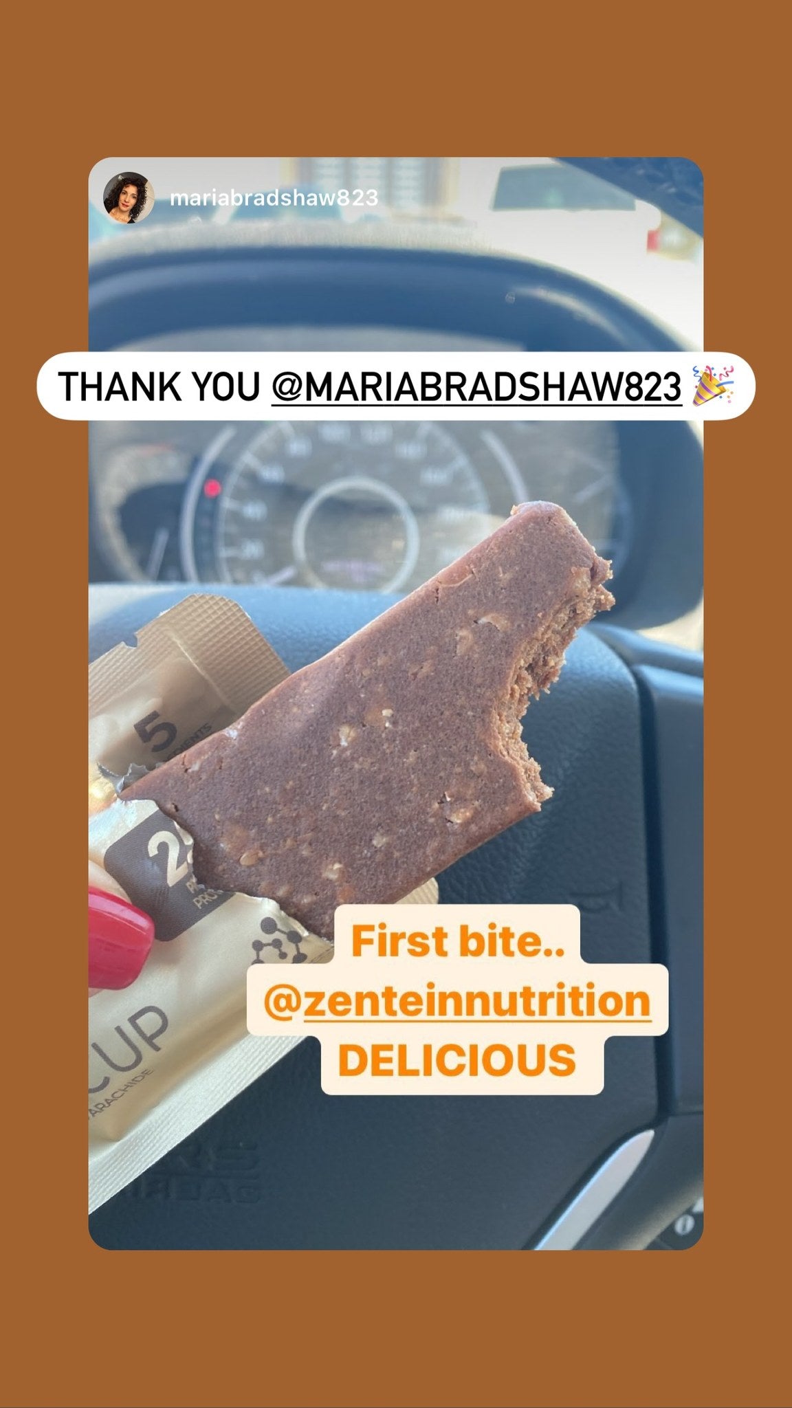 Maria holds a bitten Peanut Butter Cup bar in a car.