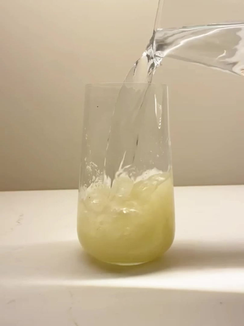 Water poured into a glass containing Zentein Superfood Collagen